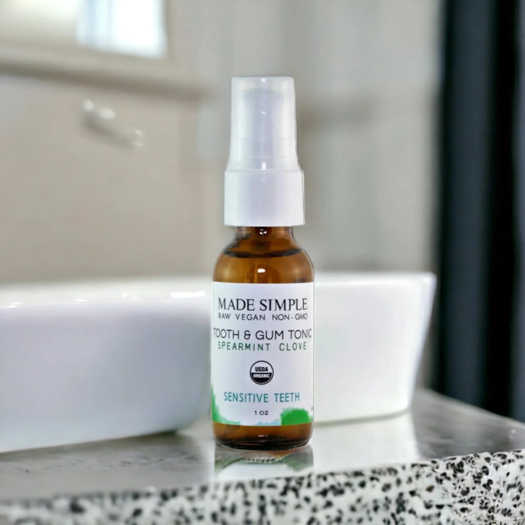 Organic tooth and gum tonic for sensitive teeth in glass dropper bottle on bathroom counter
