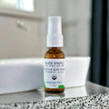 Organic tooth and gum tonic for sensitive teeth in glass dropper bottle on bathroom counter