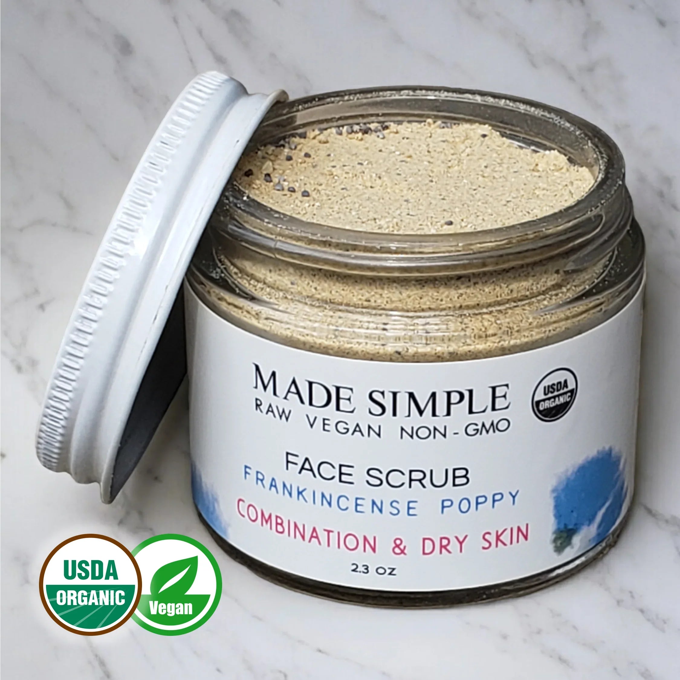 Organic vegan face scrub jar for combination and dry skin on marble surface