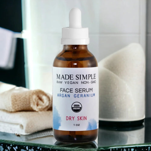 Organic vegan face serum bottle for dry skin on bathroom counter with towels