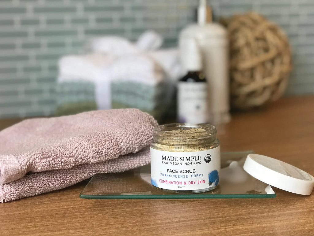 Face scrub jar with frankincense poppy for combination and dry skin on bathroom counter
