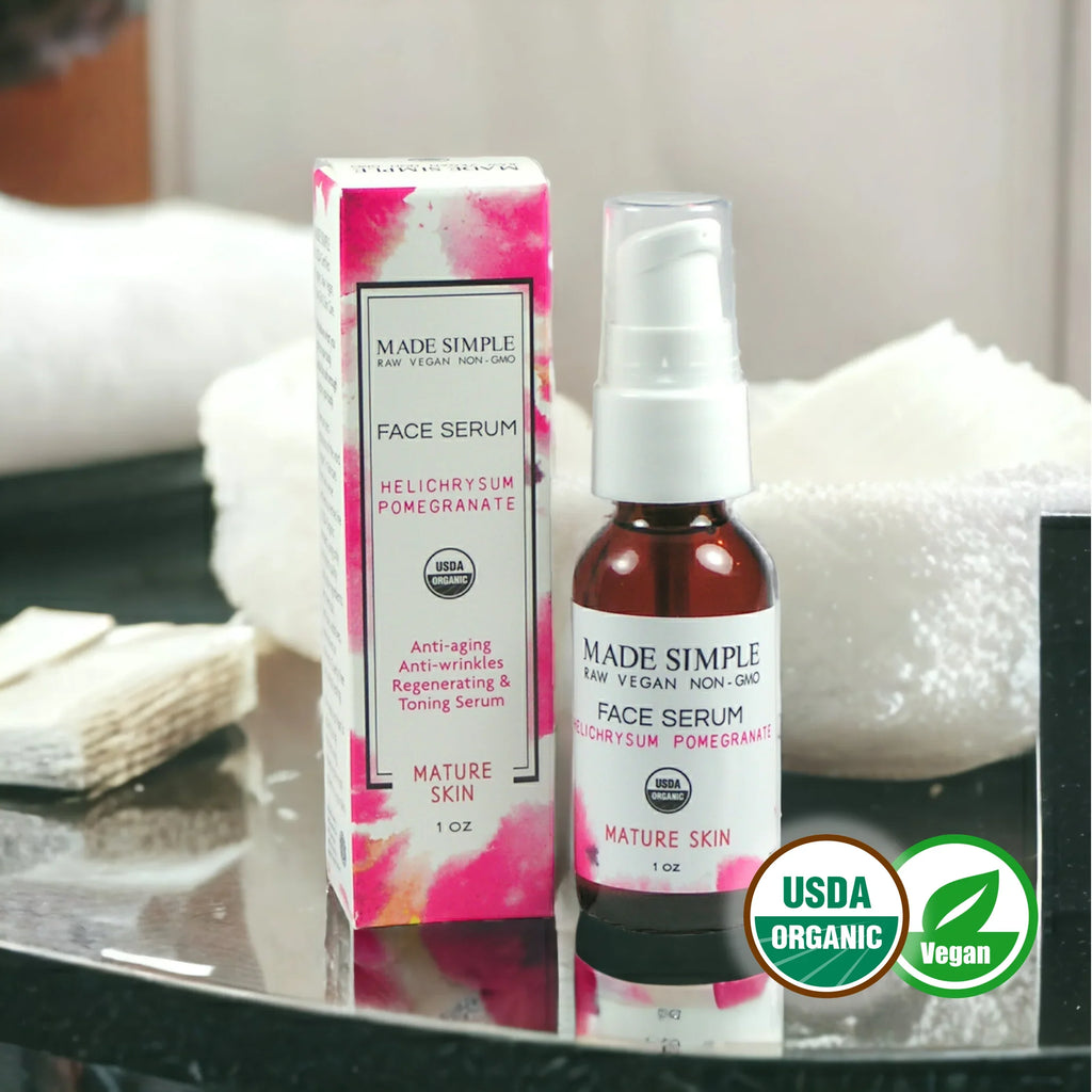 Organic vegan face serum for mature skin with box, anti-aging, USDA certified, on bathroom counter.