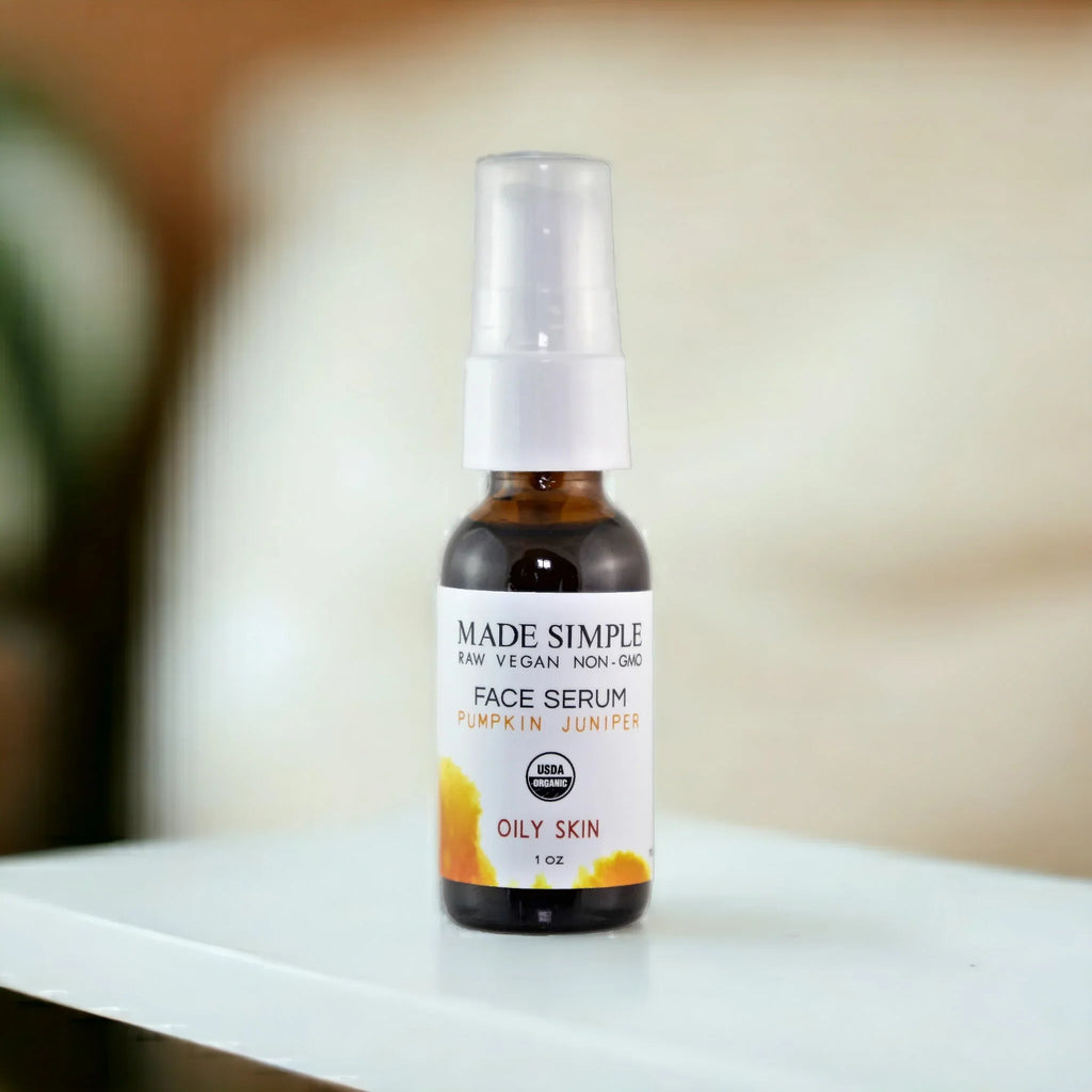 Organic pumpkin juniper face serum for oily skin in amber bottle on white table